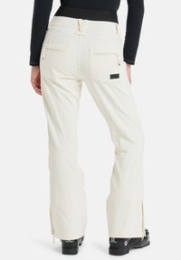 Witte skibroek met een rechte snit, twee achterzakken met ritsen en zijritsen bij de enkels. Ontworpen voor gebruik tijdens wintersport.