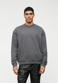 Γκρι φούτερ με στρογγυλή λαιμόκοψη και μακριά μανίκια, με ραμμένα μανίκια και τελείωμα. Διαθέτει διακριτικό λογότυπο κεντημένο στο στήθος.