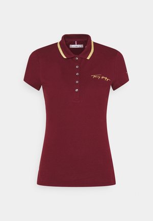 Polo bordeaux à manches courtes avec bordure dorée sur le col, la patte de boutonnage et une signature jaune brodée sur la poitrine gauche.