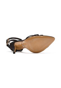 Zwarte suede hoge hakken sandaal met een puntige neus, dunne enkelbandjes en een tan rubberen zool met ribbelstructuur en een metallic accent.