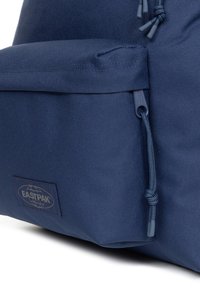 Zaino blu navy con tessuto strutturato, chiusura regolabile con coulisse e tasca frontale con il logo EASTPAK.