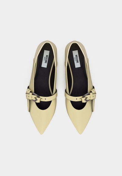 Paire de ballerines pointues jaune pâle avec des brides à boucles et des semelles intérieures noires, de la marque Moschino Milano, vues de dessus.