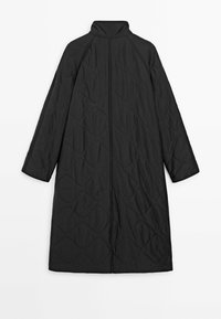 Long manteau noir matelassé avec col montant, manches longues et motif de quilting en forme de losanges, étalé à plat sur un fond blanc.