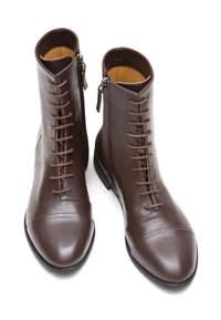 Stivali ankle in pelle marrone con finitura liscia, dotati di chiusura con lacci frontali e cerniere laterali per un facile accesso. Design della punta rotonda.