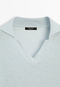 Lichtblauwe gebreide V-hals trui met een geribde kraag en een gestructureerd patroon. Het label vermeldt "Massimo Dutti," wat op het merk wijst.