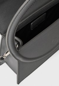 Borsa strutturata grigia con esterno testurizzato, dotata di manici eleganti, chiusura magnetica e un interno nero a contrasto.