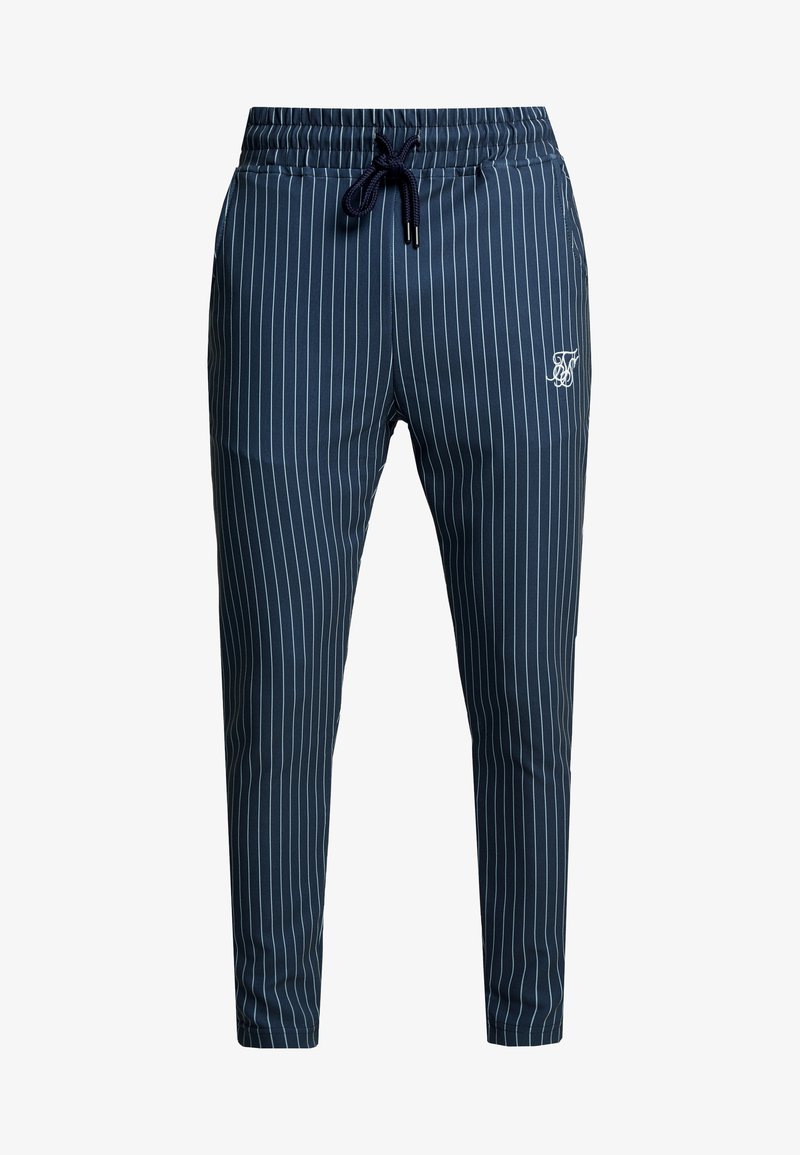 Pantalon slim bleu marine à fines rayures blanches verticales, taille élastique, cordon de serrage, poches latérales, et petit logo blanc brodé sur la cuisse.