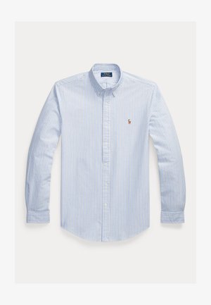 Gaiši zils svītrains krekls ar pogām, apkakli, garām piedurknēm, baltām svītrām un mazu izšūtu logotipu kreisajā krūtī.