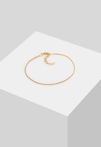 Bracciale in oro con un fine design a catena testurizzata e chiusura regolabile. Presenta un piccolo prolungamento della catena per la regolazione della misura.