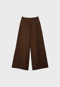 Pantalons marron à taille haute et coupe évasée avec des détails de boutons à l'avant et deux poches passepoilées horizontales sur fond uni.