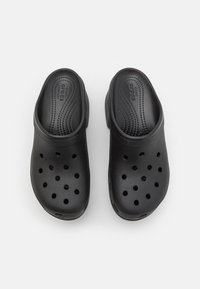 Sabots noirs à enfiler avec des trous de ventilation et des semelles moulées étiquetées "Crocs Comfort,", vus de dessus sur un fond clair.