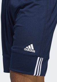 Navyblaue Sportshorts aus atmungsaktivem Material mit weißem Adidas-Logo und drei Streifen an der Seite. Elastischer Bund.