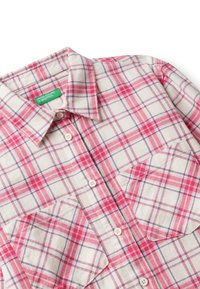 Camicia button-up a quadri bianca e rosa con due tasche sul petto e un'etichetta verde "United Colors of Benetton" all'interno del colletto.