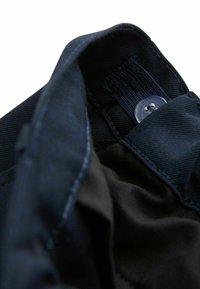 Tumesinise kangaga krae hõbedase nööbi detailiga. Tekstuuriga materjal nähtavate õmblustega. Sisemine vooder kontrastse musta värvusega.