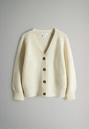 Cremefarbener Strickcardigan mit V-Ausschnitt, gerippter Textur und sechs dunklen Knöpfen. Verfügt über lange, leicht gepuffte Ärmel und einen lockeren Schnitt.