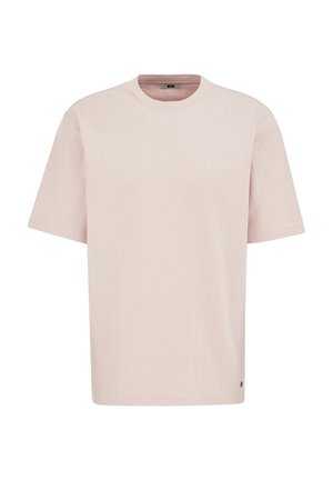 Svetlo roza majica s kratkimi rokavi in okroglim ovratnikom, z nežno navpično rebrasto teksturo in majhnim kovinskim logotipom blizu spodnjega roba.