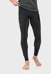Schwarze Sportleggings mit glatter Textur, ausgestattet mit einem weichen Bund sowie einer sichtbaren Naht und Tasche an der Seite.