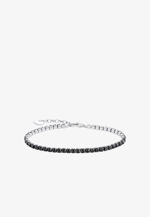 Armband in Silberoptik mit schwarzen Zirkoniasteinen, die in einer flexiblen Kette eingefasst sind, mit einem Karabinerverschluss und Verlängerungskette für Verstellbarkeit.