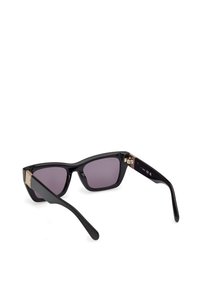 Gafas de sol negras de estilo cat-eye con lentes tintados en púrpura. Presentan detalles en oro en las patillas. Textura suave y brillante en toda la superficie.