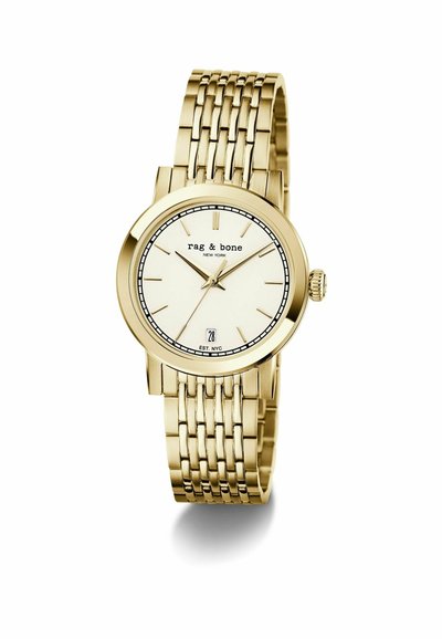 Ceas de mână din metal cu nuanță aurie, cu cadran alb, indicatori subțiri pentru ore, marcă rag & bone, fereastră pentru dată la ora șase și curea cu brățară legată.
