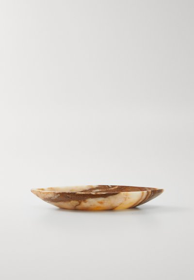 Marmorteller mit braunen, beige und cremefarbenen Wirbelmustern, flach auf einer weißen Oberfläche mit einem schlichten weißen Hintergrund präsentiert.