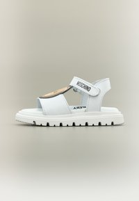 Λευκό βρεφικό σανδάλι με ρυθμιζόμενο λουράκι, λογότυπο Moschino και σχέδιο προσώπου αρκούδας στο μπροστινό μέρος, με παχύ, ραβδωτό πάτο.