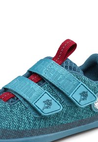 Zapato de escalada azul con parte superior de malla texturizada, correa de acento roja y dos cierres de Velcro ajustables. Suela de goma y puntera reforzada.