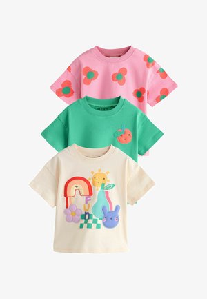 Three short-sleeve kids' t-shirts in pink with orange flowers, green with a peach patch, and cream with colorful cartoon designs.