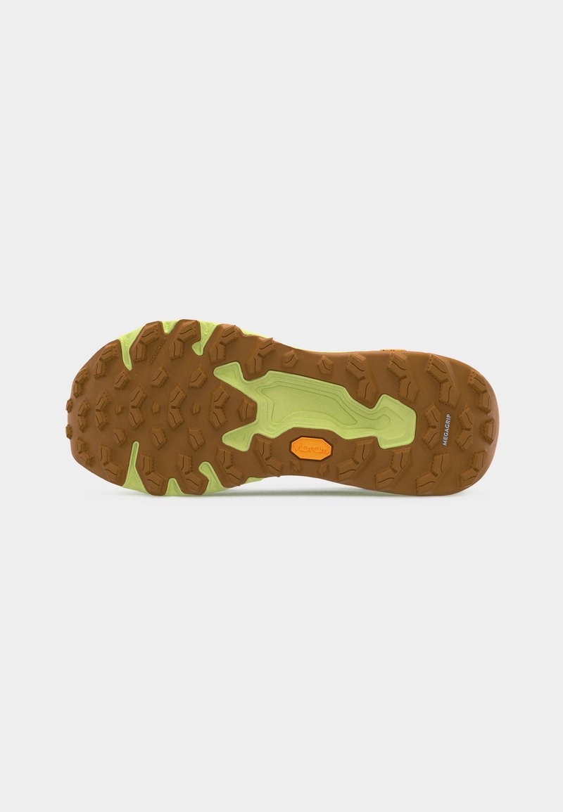Suela de zapato de trail con tacos multidireccionales en marrón y verde claro, etiquetados como "Vibram" y "MegaGrip" para una tracción mejorada.