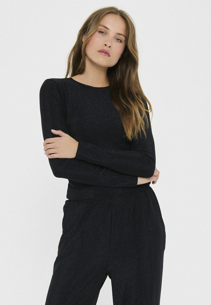 Čierny dlhý rukáv top z lesklého materiálu s okrúhlym výstrihom. Strih je priliehavý, s hladkou textúrou a minimálnymi dizajnovými detailmi.