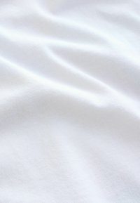 Bijela pamučna tkanina s glatkom teksturom, koja sadrži suptilne nabore i blistavi sjaj. Ujednačena površina bez uzoraka ili tehničkih detalja.