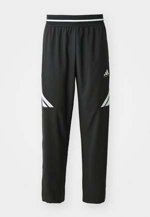 Svarta Adidas basketbyxor med vita ränder på låren och ett elastiskt midjeband med svart och vitt mönster.