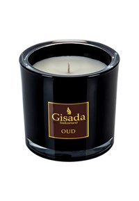 Schwarzer Glaskerzenhalter mit einem weißen Wachsintern und einem zentralen Docht. Verfügt über ein goldbraunes Etikett mit dem Text "Gisada Switzerland OUD."