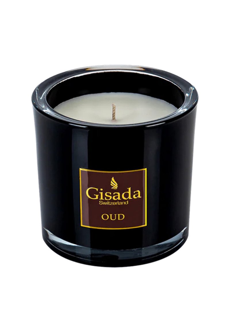 Schwarzer Glaskerzenhalter mit einem weißen Wachsintern und einem zentralen Docht. Verfügt über ein goldbraunes Etikett mit dem Text "Gisada Switzerland OUD."