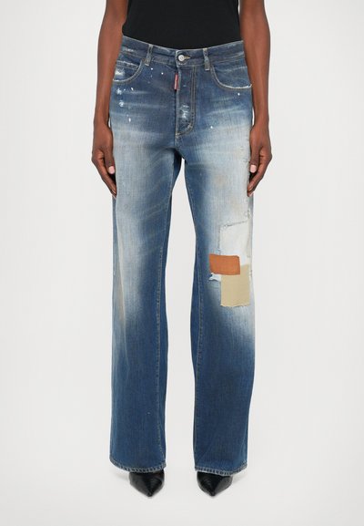 Wijd gevallen blauwe denim jeans met distressed details, patchwork accenten in tan en crème, en een vervaagde wasbeurt met een licht gestructureerd oppervlak.