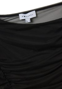 Indumento nero realizzato in un tessuto leggero e liscio, con texture arricciata e un'etichetta con informazioni su marca e taglia.