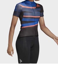 Dámský cyklistický dres s krátkým rukávem v modré a černé barvě s červenými akcenty, s předním zipem a pruhovaným designem. Doplněný o černé cyklistické kraťasy.