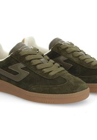 Baskets en suède vert olive avec des accents en cuir marron, lacets ronds et semelle en caoutchouc gomme. Présente des détails texturés sur la languette.