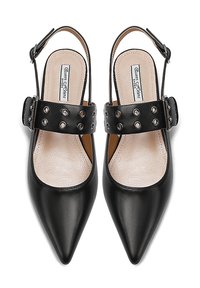 Scarpe slingback nere in pelle con punte appuntite, caratterizzate da una larga fascia con ritagli circolari e chiusura a fibbia. Soletta liscia e testurizzata.