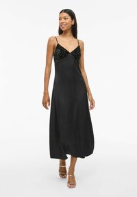 Vestido maxi de satén negro con un escote en forma de V, que presenta un corsé adornado con cuentas y lentejuelas, y finas tiras ajustables.