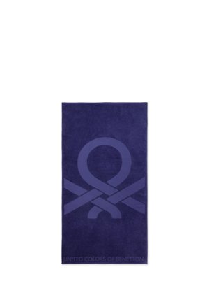 Donkerblauwe handdoek met een groot lintlusontwerp in het midden en de tekst "United Colors of Benetton" onderaan.