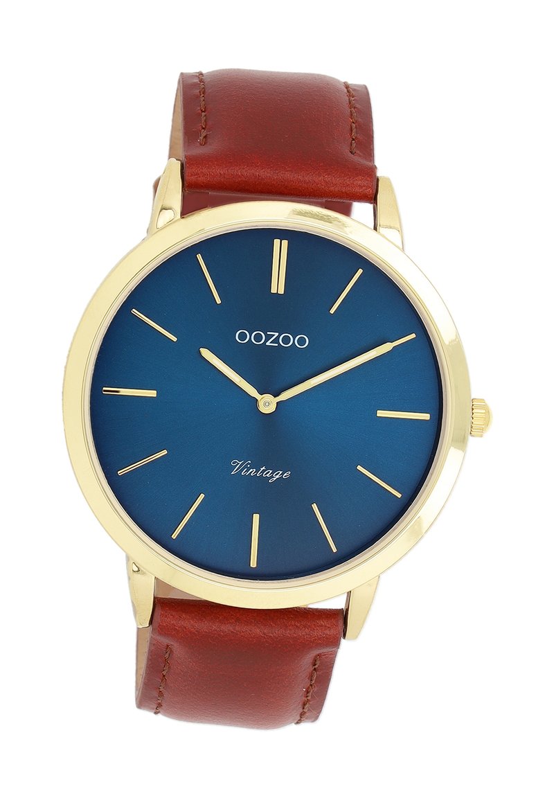Montre dorée avec un cadran bleu rond, marqueurs d'heure minimalistes et strap en cuir marron. Présente le texte 'Vintage' au-dessus de la marque de 6 heures.