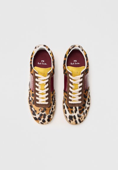 Sneaker con stampa leopardata, upper in pelliccia testurizzata, dettagli in pelle marrone, linguetta gialla e lacci bianchi su una suola beige.