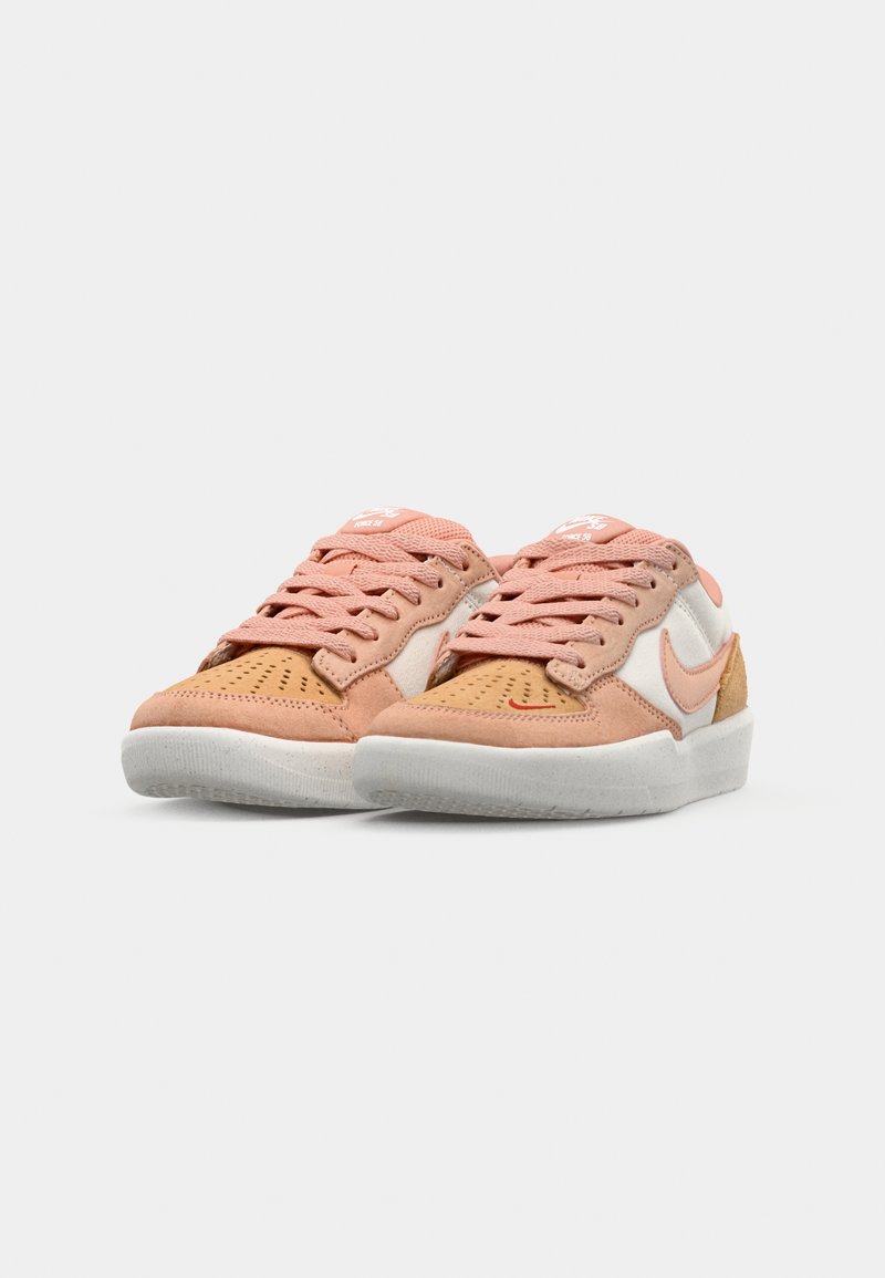 Zapatillas de deporte en tonos marrón y rosa con parte superior de ante y malla, logo Swoosh blanco y suela de goma texturizada. Presenta cordones contrastantes y perforaciones.