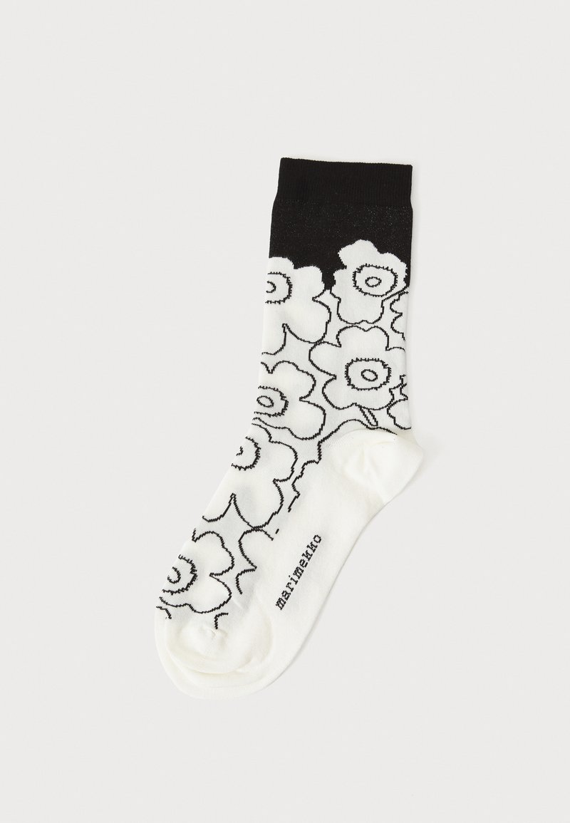 Calzini in bianco e nero con un motivo floreale su uno sfondo crema. Realizzati in tessuto morbido, con un bordo nero solido e un logo sulla punta.