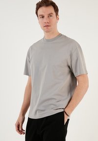 Grå kortærmet T-shirt i blødt materiale med rund halsudskæring, der har en afslappet pasform og ingen synlige mønstre eller grafik.