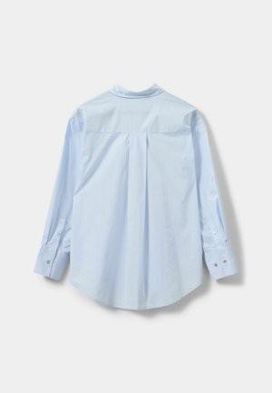 Gai zila garo piedurkņu krekls ar aizmugurē plecu, pogu aprocēm un klasisku apkakli. Gluda tekstūra ar vienkāršu dizainu.