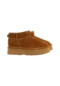 Bottes chelsea en daim marron avec un bout arrondi, une large sangle et une semelle en caoutchouc. Le design comprend une languette à l'arrière pour un enfilage facile.