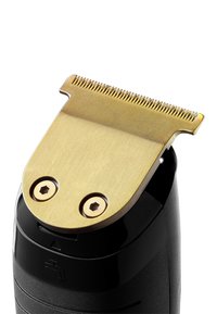 Svart trimmer med ett guldmetallbladstillsats. Bladet har jämnt fördelade tänder och två synliga skruvar för säker fastsättning.