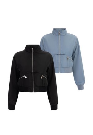 Deux vestes zippées avec col haut et manches longues, une noire et une bleu clair, toutes deux dotées de poches zippées et de poignets élastiques.